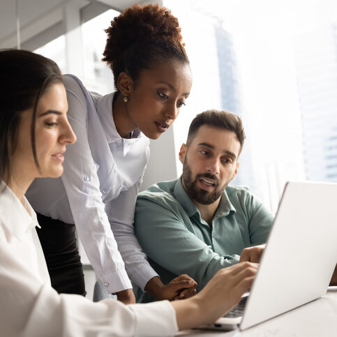Multiethnic team of focused managers working on Internet project together